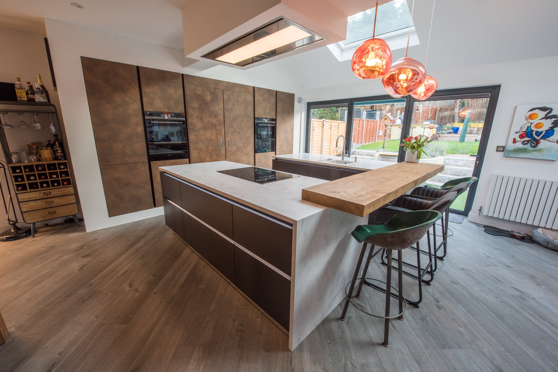 Contemporary kitchen with a generous island, timber breakfast bar and copper pendant lights